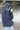 Fishr Chicks navy hibiscus hoodie worn by woman outdoors near water with hood up