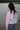 Fishr Chicks salmon pink logo hoodie worn by person standing near water in casual jeans